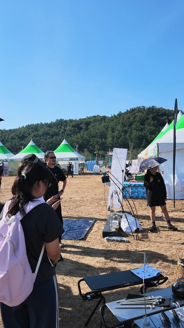텐트와 부스 사이를 걸으며 둘러보는 학생들