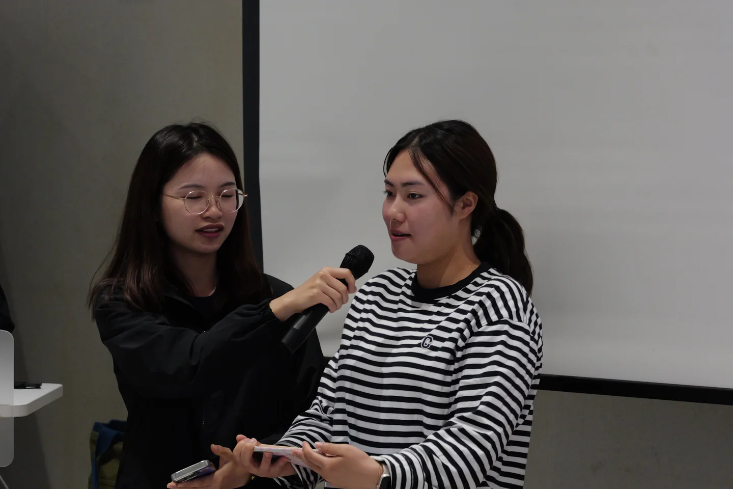 마이크를 나눠 들고 영상을 소개하는 두 학생
