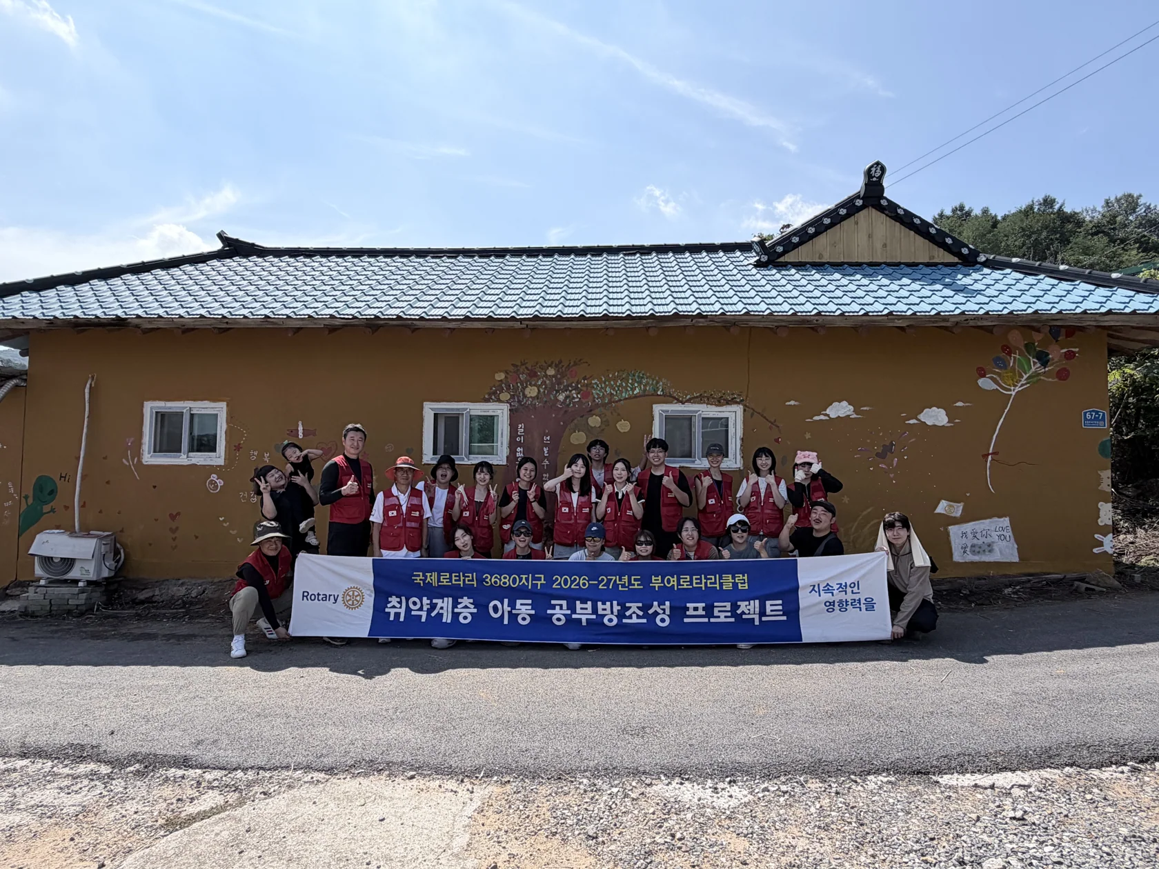 The Buyeo Rotary Club and young visitors from Taiwan beside the finished mural