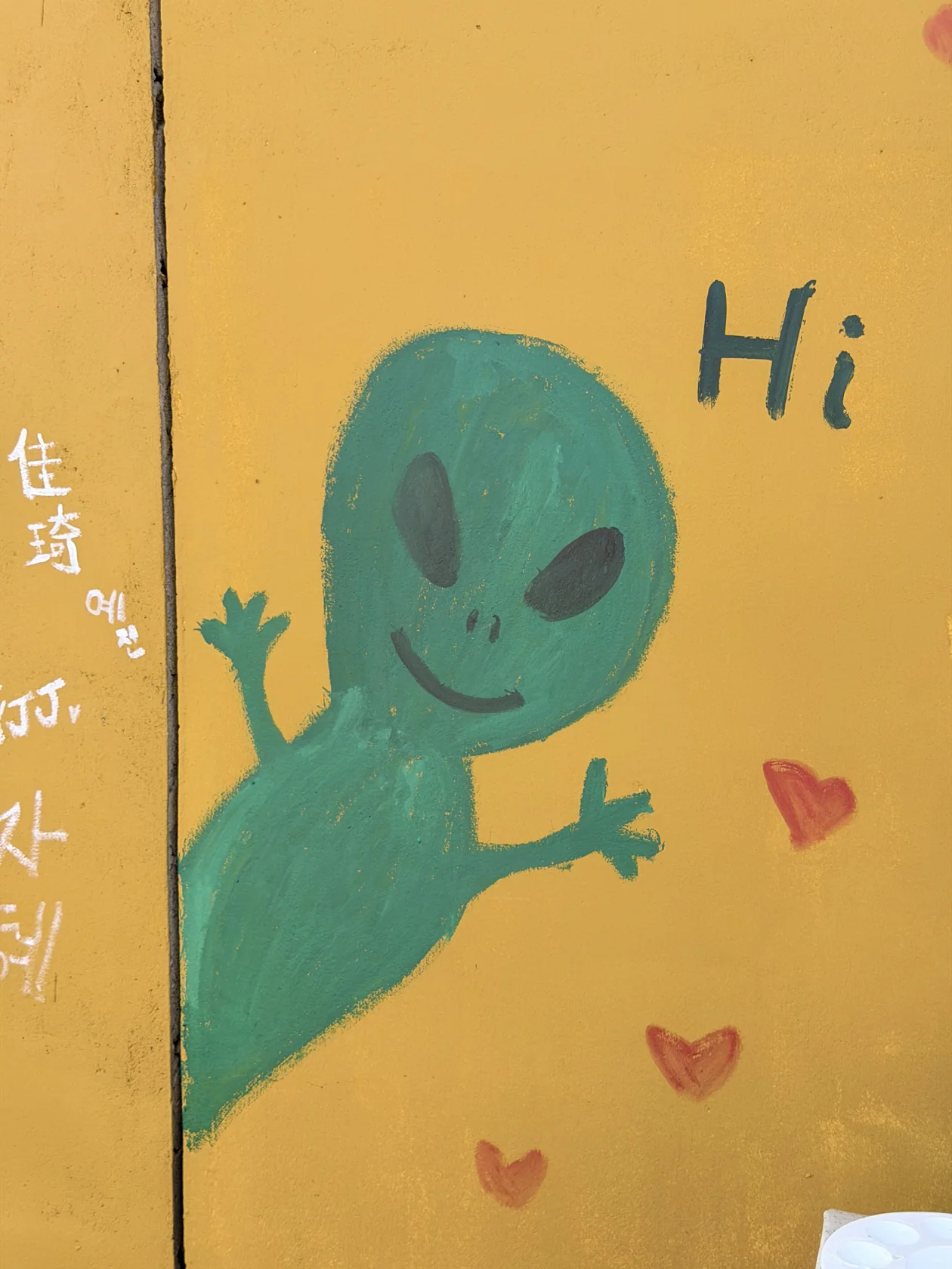A green hello on a yellow wall