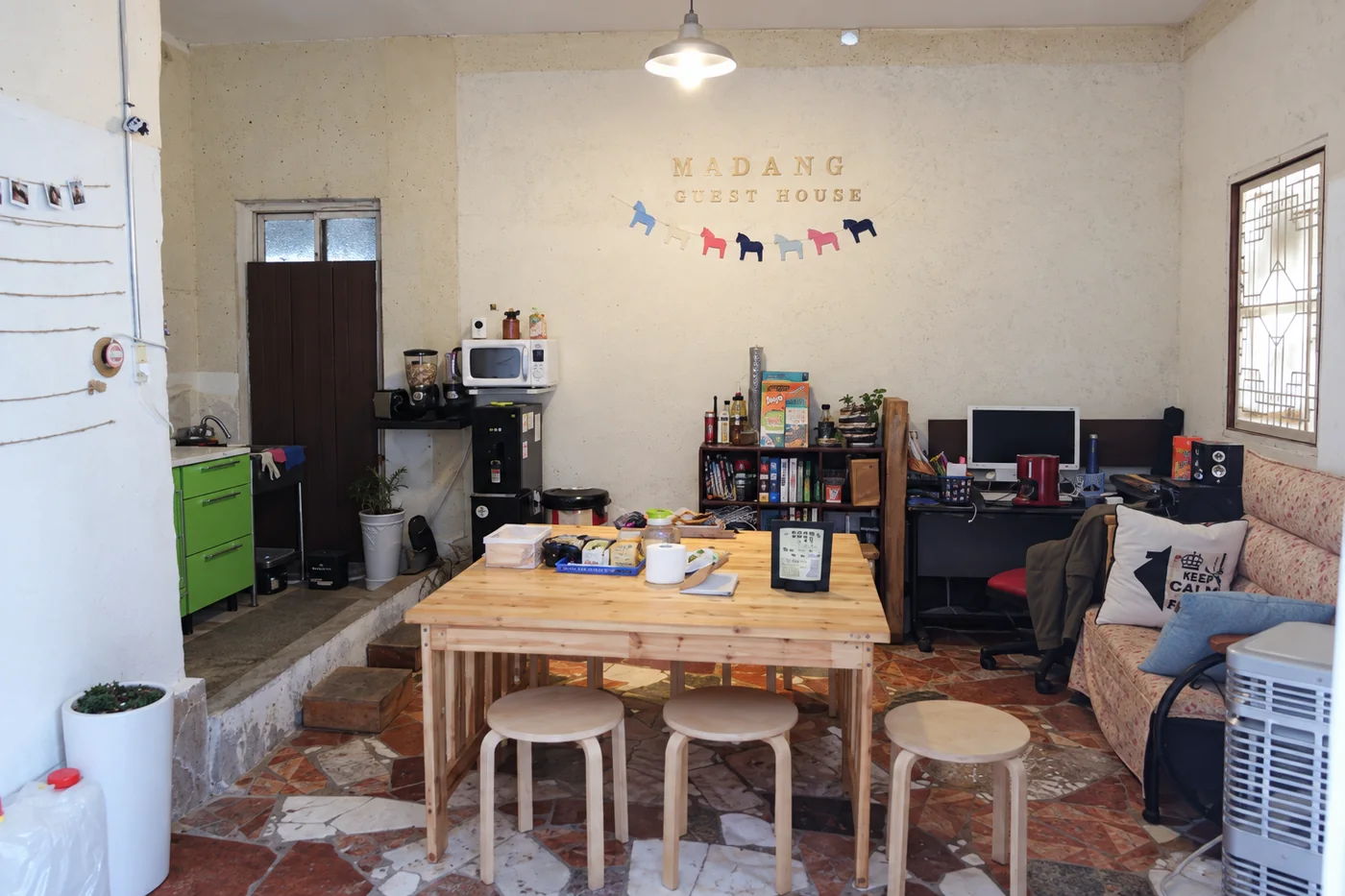 MADANG GUEST HOUSE 글자가 붙은 공용 라운지와 부엌